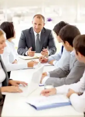 A group of professionals sitting around a table discussing how to fire your employee - Vision Law